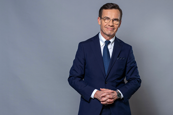 Porträttbild på Ulf Kristersson mot grå bakgrund.