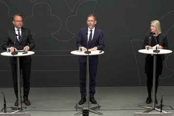 De medverkande står bakom var sin talarpulpet.