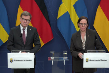 De två medverkande avbildade framifrån i halvfigur bakom var sin talarstol.