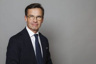 Porträtt i halvfigur på Ulf Kristersson mot grå bakgrund.