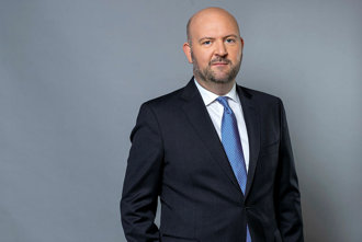 Porträtt i halvfigur på Johan Stuart mot grå bakgrund.