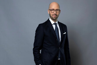 Porträtt i halvfigur på Per Swenson Claréus mot grå bakgrund.