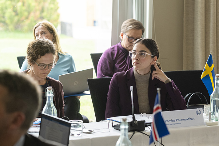 Klimat- och miljöminister Romina Pourmokhtari lyssnar på sina kollegor runt ett bord