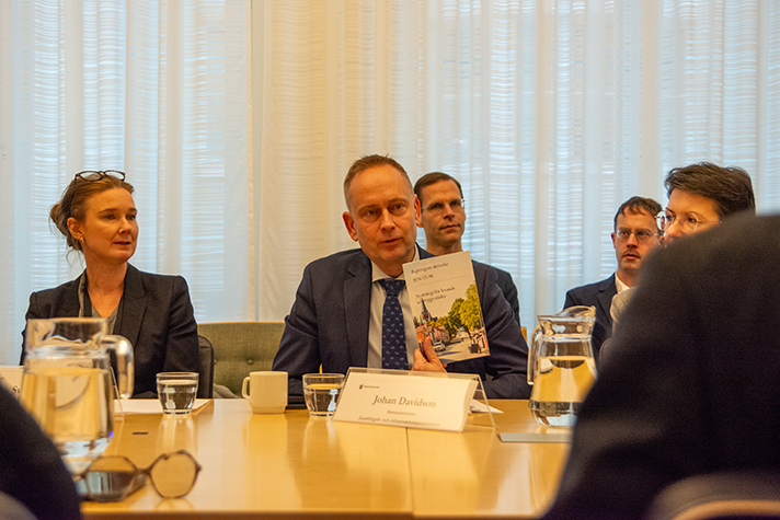 Närbild på Johan som håller upp en skrivelse som heter Ny strategi för levande och trygga städer.