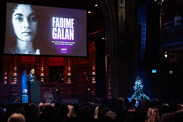 Statsministern står på en scen vid ett podium och håller tal.