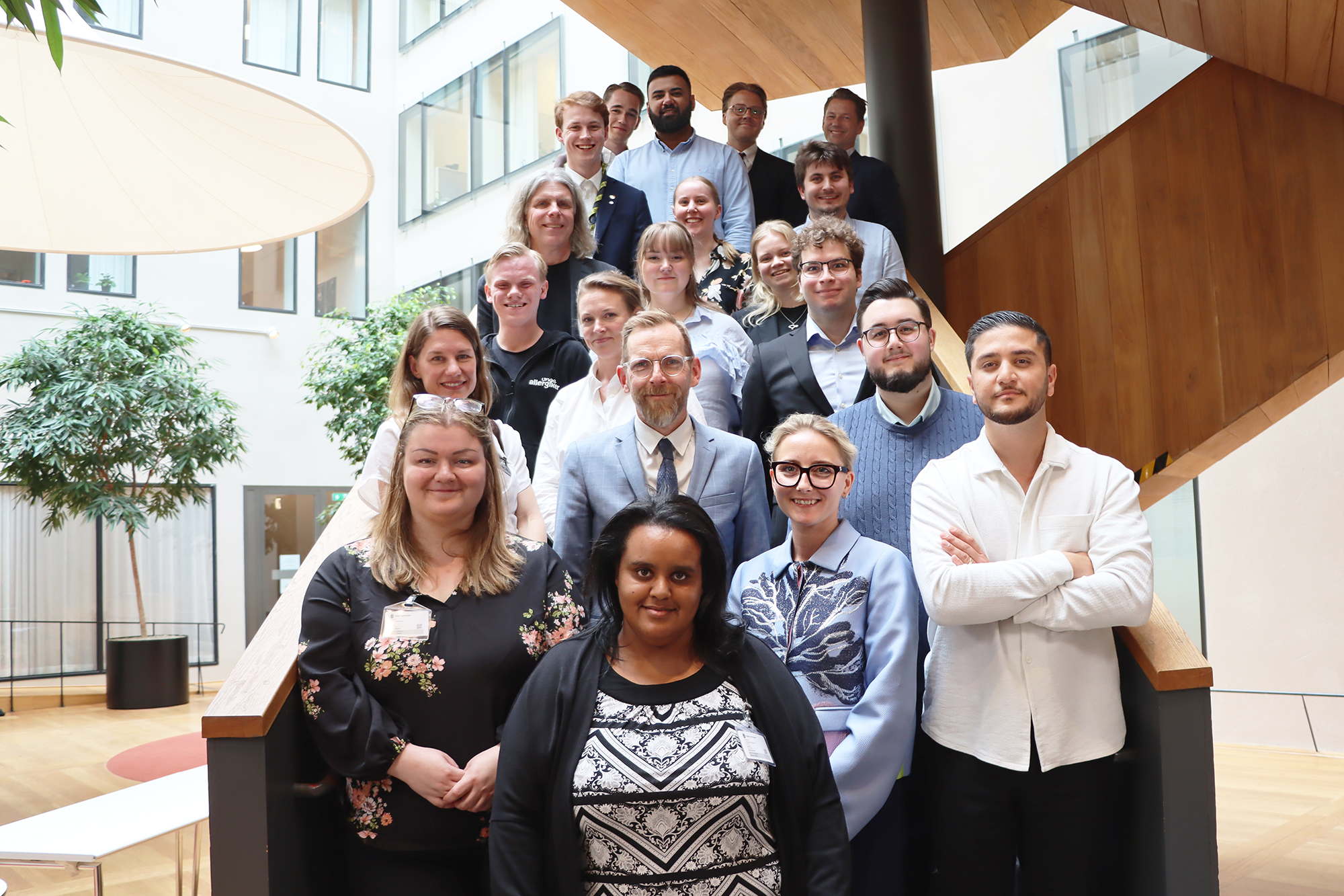 Gruppfoto på deltagarna vid Ungdomspolitiska rådets möte. De står i en trappa med socialministern i mitten. 
