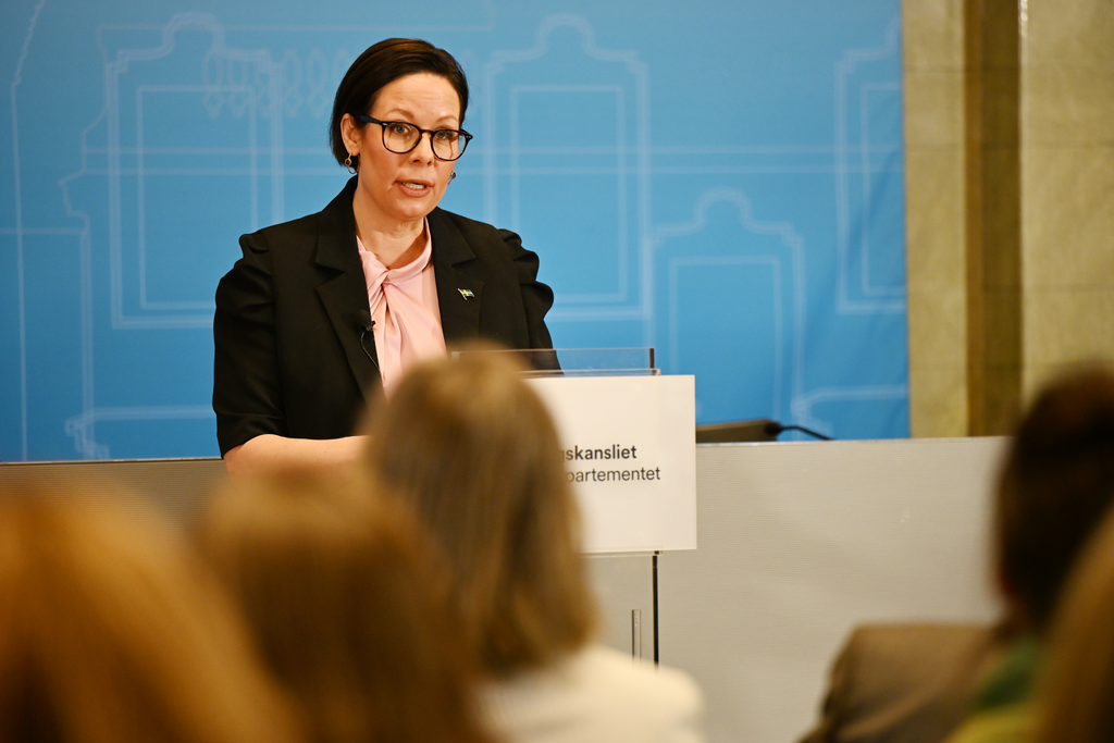Utrikesminister Maria Malmer Stenergard talar vid talarstol.