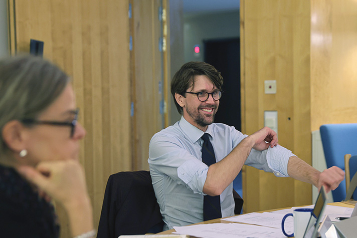 Man i skjorta sitter på ett möte