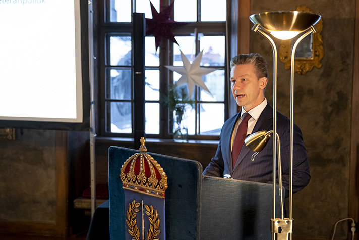 Pål Jonson presenterar veteranstrategin talandes vid ett podium.