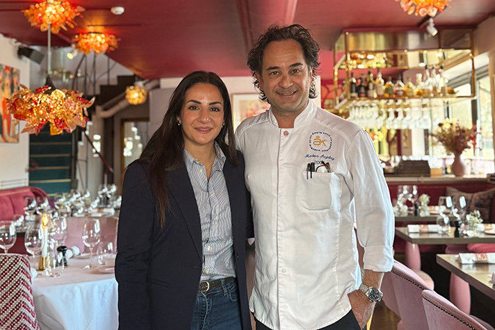 Parisa Liljestrand till vänster och Markus Aujalay till höger. Rosa inredning och dukade bord i bakgrunden.