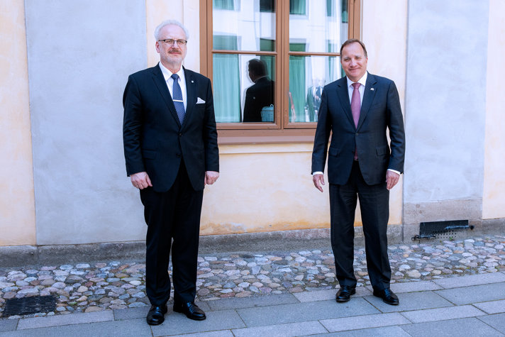 Stefan Löfven och Egils Levits står ute på en gårdsplan,
