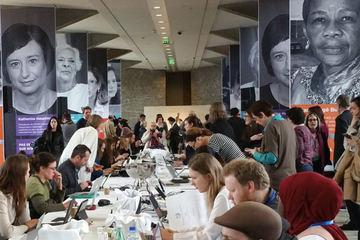 Massa människor vid ett bord som skriver på datorer
