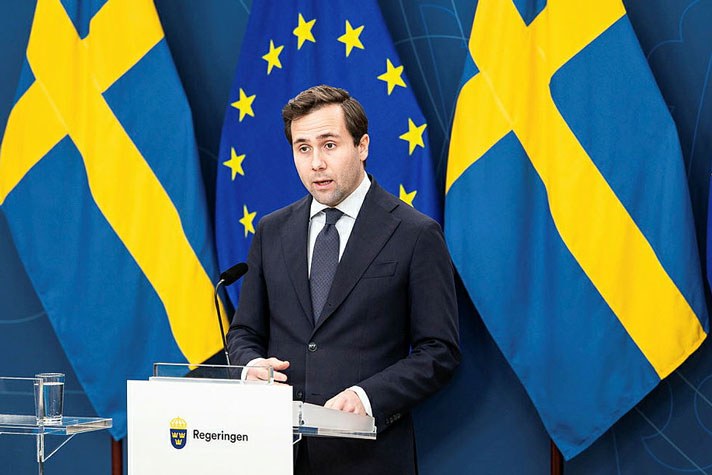 Bistånds- och utrikeshandelsminister Benjamin Dousa står vid en talarpulpet.