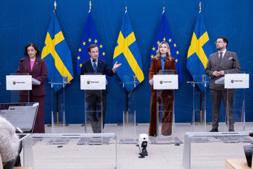 De fyra medverkande står bakom var sin talarstol.