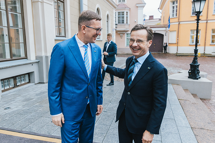 Kristen Michal och Ulf Kristersson står utomhus på en trappa i Tallinn.