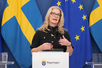 Lotta Edholm bakom en talarstol i regeringens pressrum.