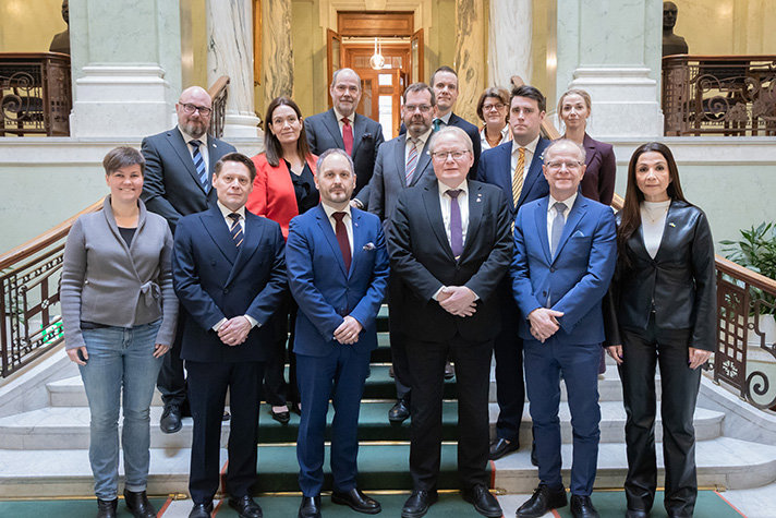 Flera personer står på rad inne i riksdagen.