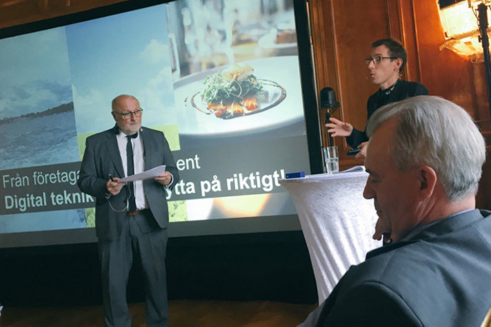 Två män står och talar till en grupp. I förgrunden ser man Sven-Erik Bucht, landsbygdsministern.