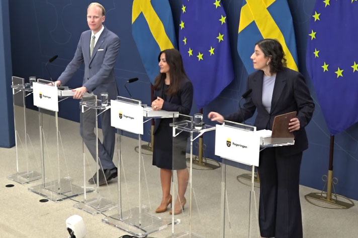 De tre medverkande står vid var sin talarpulpet.