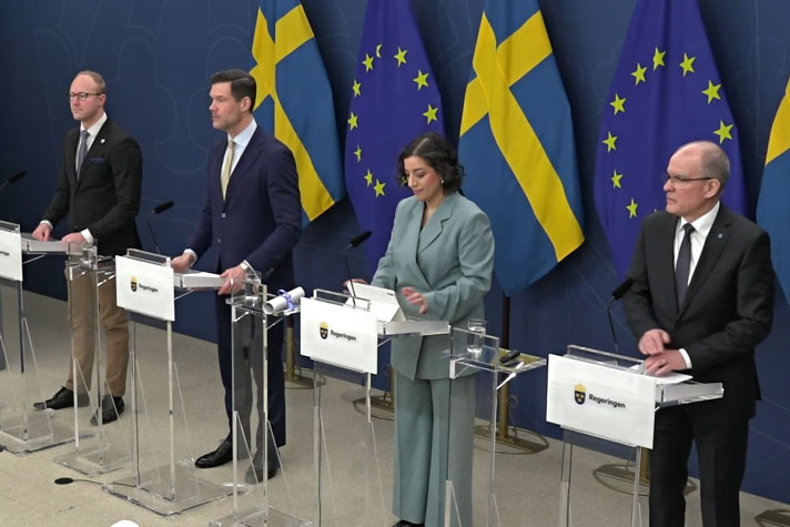 De medverkande avbilda snett uppifrån vid var sin talarstol.