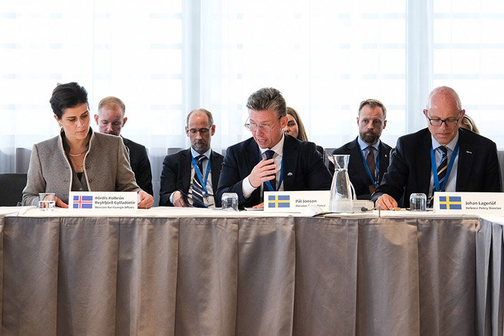 Försvarsminister Pål Jonson talar i en mikrofon på ett möte.