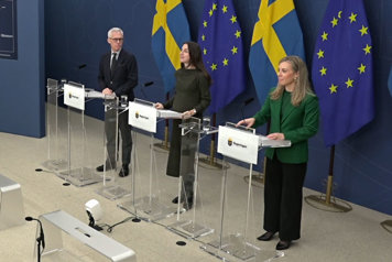 Tre personer avbildade snett uppifrån vid var sin talarpulpet.