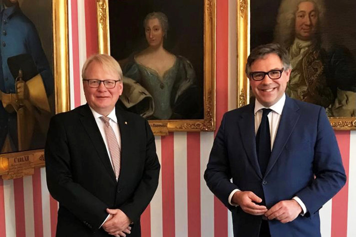 Peter Hultqvist och Jeremy Quin i kostym med tavlor i bakgrunden.