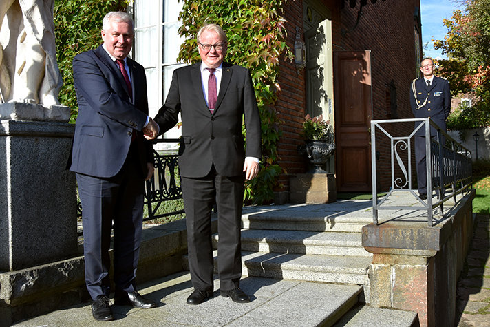 Försvarsminister Peter Hultqvist och Litauens försvarsminister Arvydas Anušauskas skakar hand utomhus.