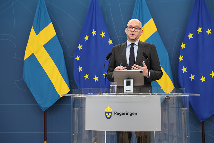 Arbetsmarknadsminister Johan Britz står vid ett podium i pressrummet Rosenbad och talar..