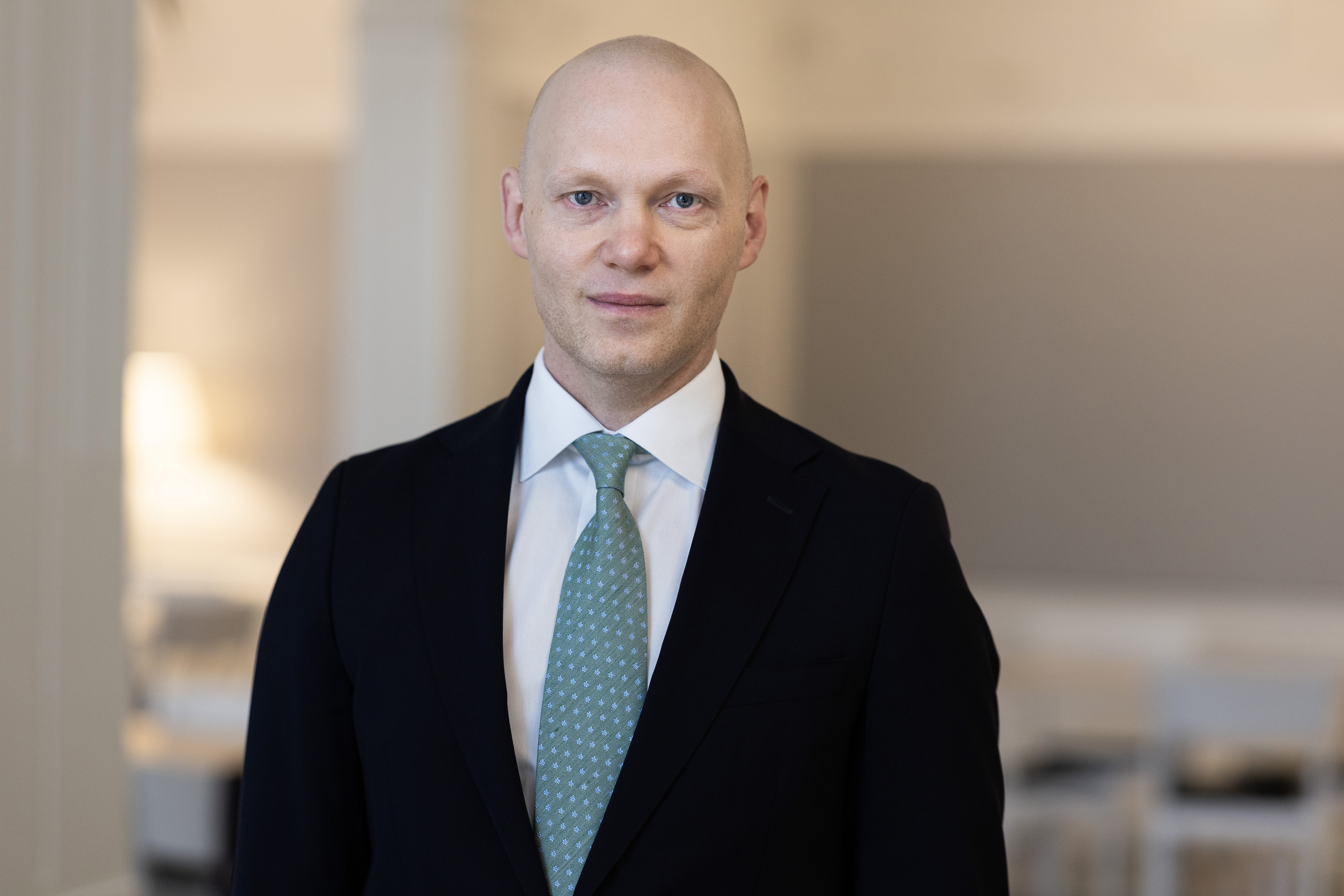 Man i kostym, portträttbild. Suddig bakgrund.