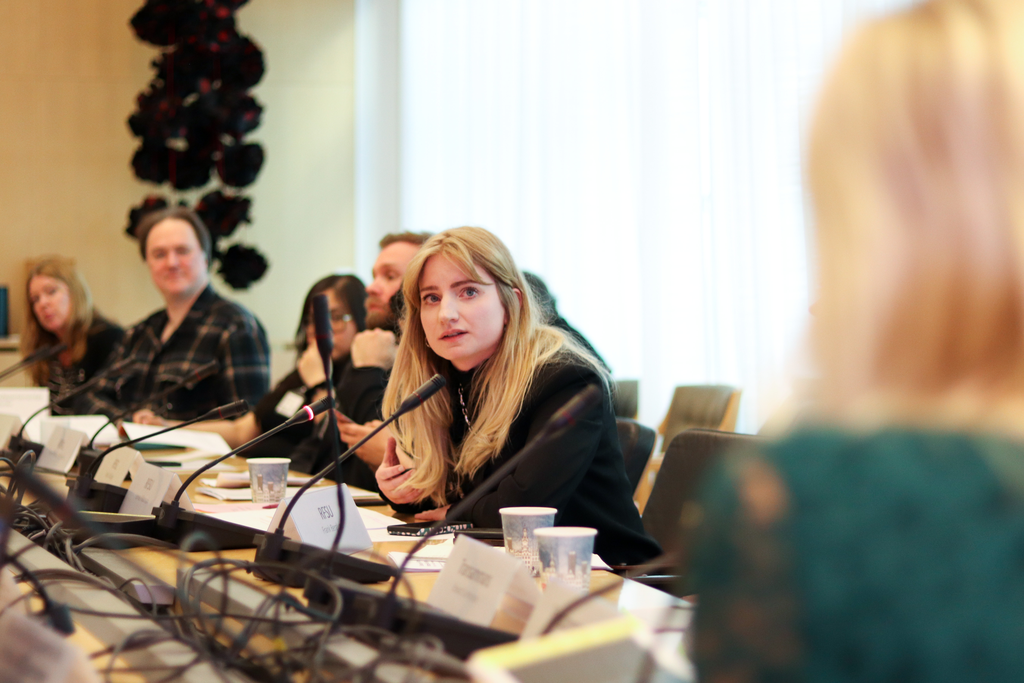 Flera personer sitter vid ett bord och pratar.