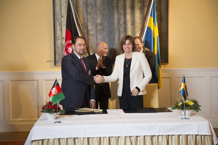 Biståndsminister Isabella Lövin och en representant för Afghanistan undertecknar ett samarbetsavtal
