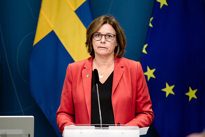 Miljö- och klimatminister Isabella Lövin framför en EU-flagga och en svensk flagga på en pressträff i september i år.