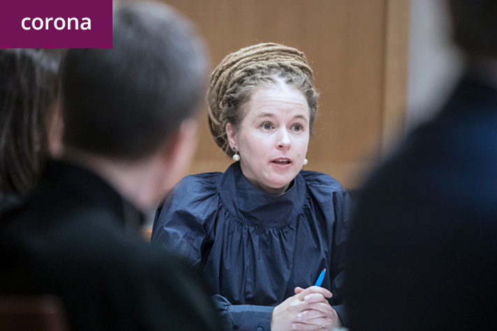 Amanda Lind sitter vid ett bord i ett konferensrum och talar med aktörer inom begravningsverksamheten.