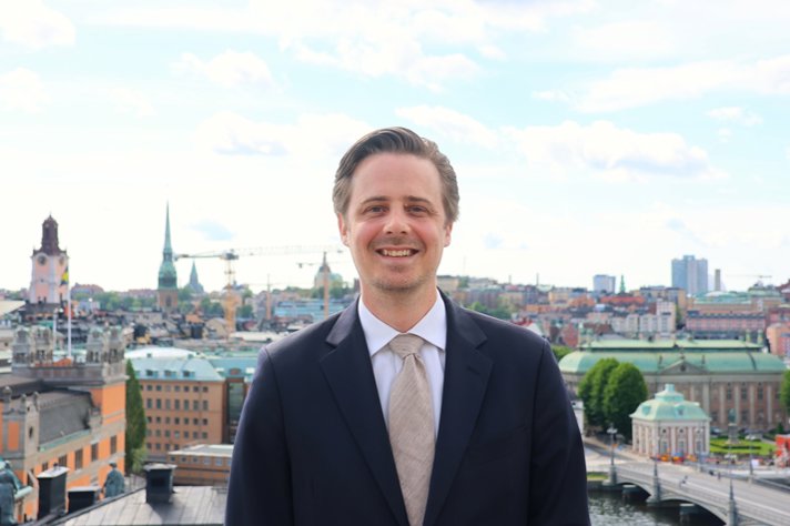 Henrik står på en takterass. I bakgrunden syns Stockholms innerstad
