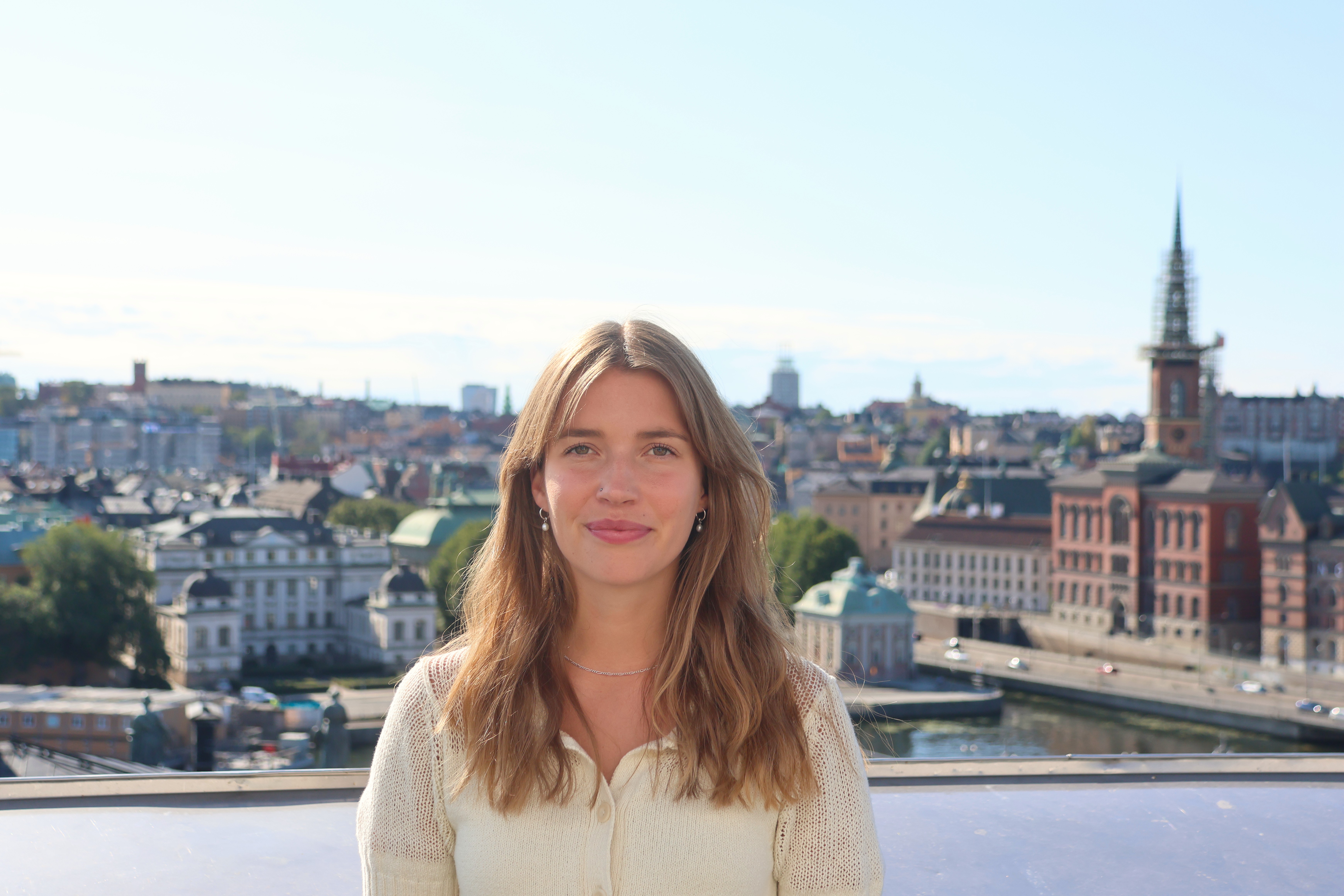 Stella Orback på en takterrass. I bakgrunden syns Stockholms innerstad.