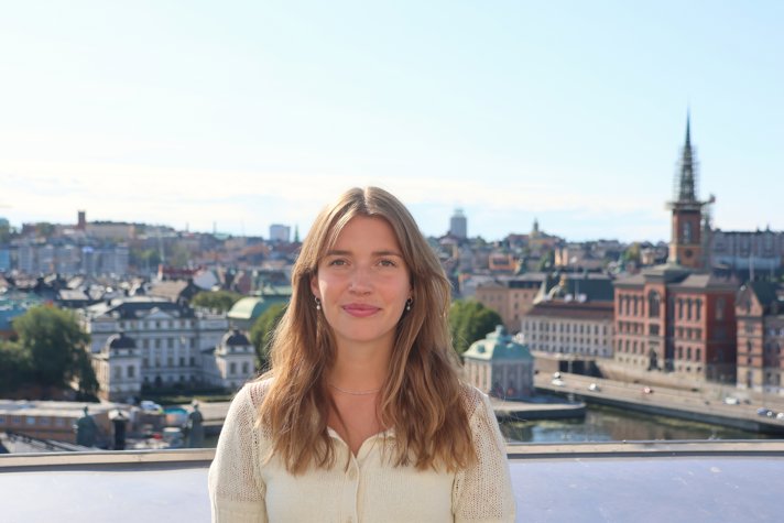 Stella Orback på en takterrass. I bakgrunden syns Stockholms innerstad.
