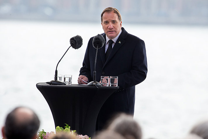 Statsminister Stefan Löfven står utomhus och talar. 