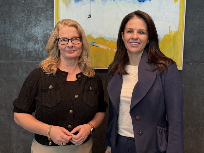 Ministrarna står framför en vägg och ler mot kameran.