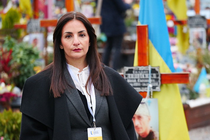 Parisa Liljestrand framför kransar mm vid Ukrainian War Memorial Cemetery.