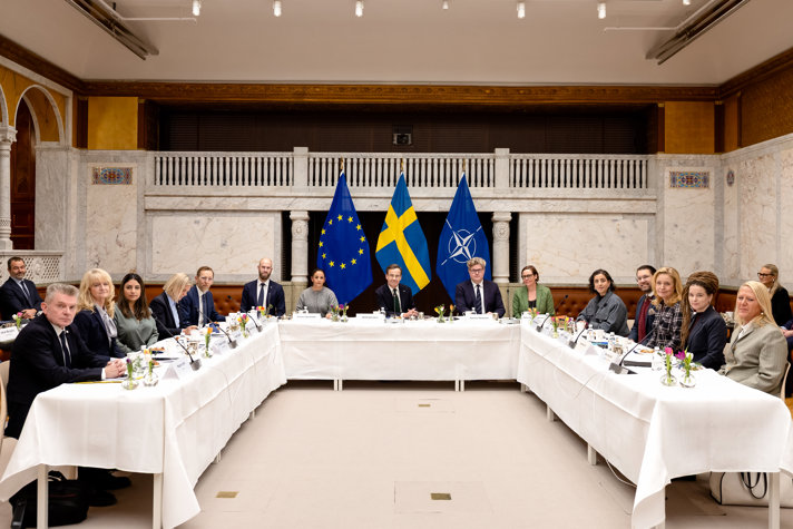 Partiledarna runt ett mötesbord.