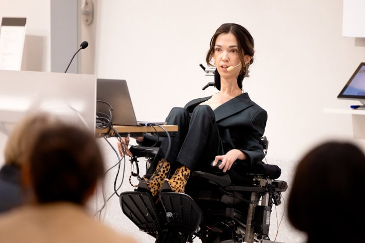 Kvinna i rullstol håller tal.