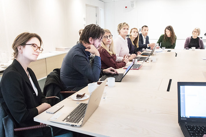 Deltagarna sitter runt ett bord och diskuterar.