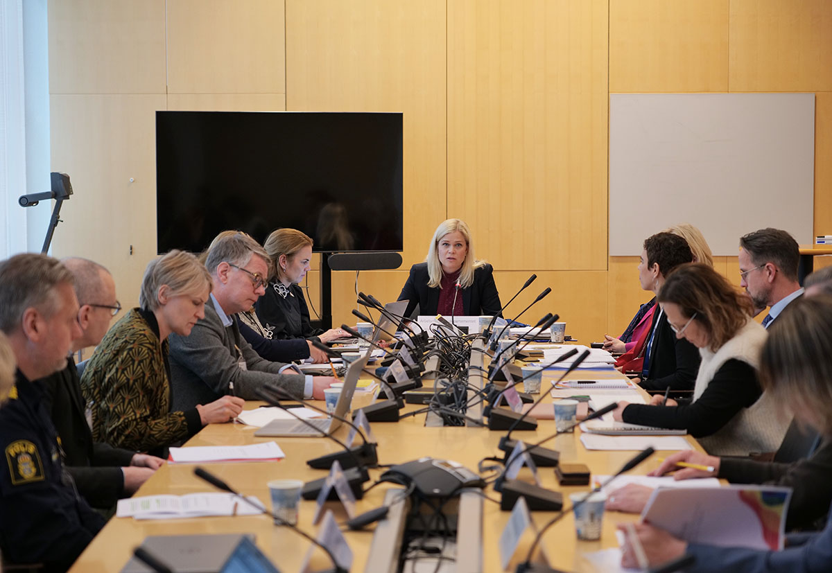Flera personer sitter runt ett stort sammanträdesbord.