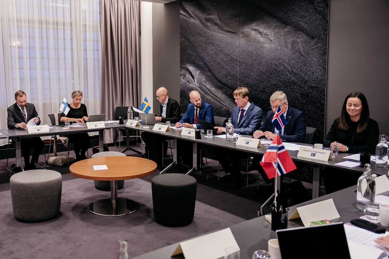Representanter från samtliga deltagande länder sitter vid bord i ett mötesrum och pratar med varandra.