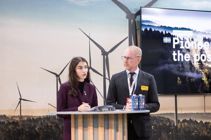 Klimat- och miljöminister Romina Pourmokhtari och chefsförhandlare Mattias Frumerie bredvid varandra vid podium
