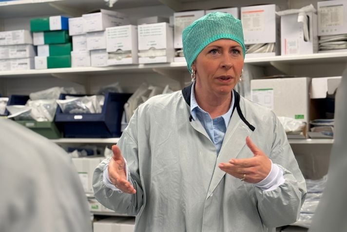 Sjukvårdsminister Elisabet Lann under ett verksamhetsbesök på Alingsås Lasarett iklädd operationsmössa och skyddsförkläde.