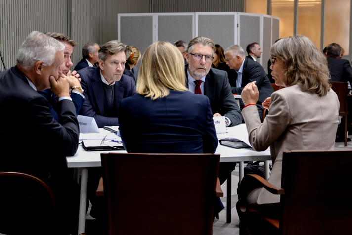 Flera personer sitter runt ett bord och pratar.