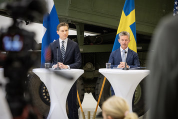 Finlands försvarsminister Antti Häkkänen och försvarsminister Pål Jonson står bredvid varandra bakom ett bord.