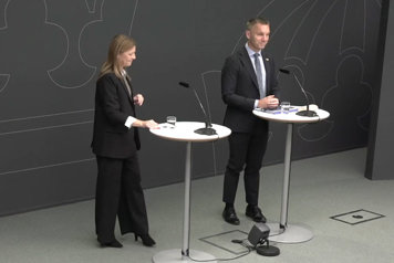 Utredare Anneli Berglund Creutz och civilminister Erik Slottner avbildade snett uppifrån stående vid var sitt ståbord.